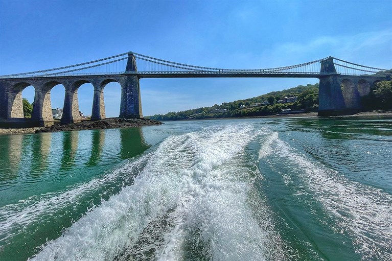 A dramatic view of the Menai Bridge from the water